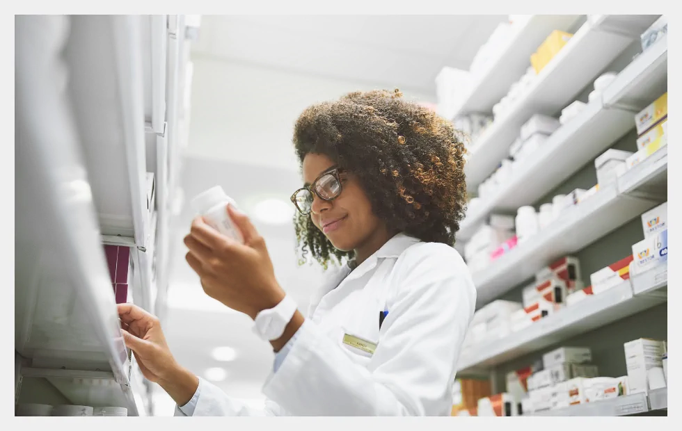 Pharmacist checking medication shelves Pharmacist checking medication shelves